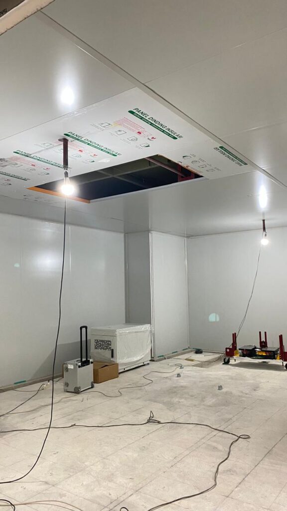 Sandwich panel ceiling being installed inside the scanner room, with a service bay left open