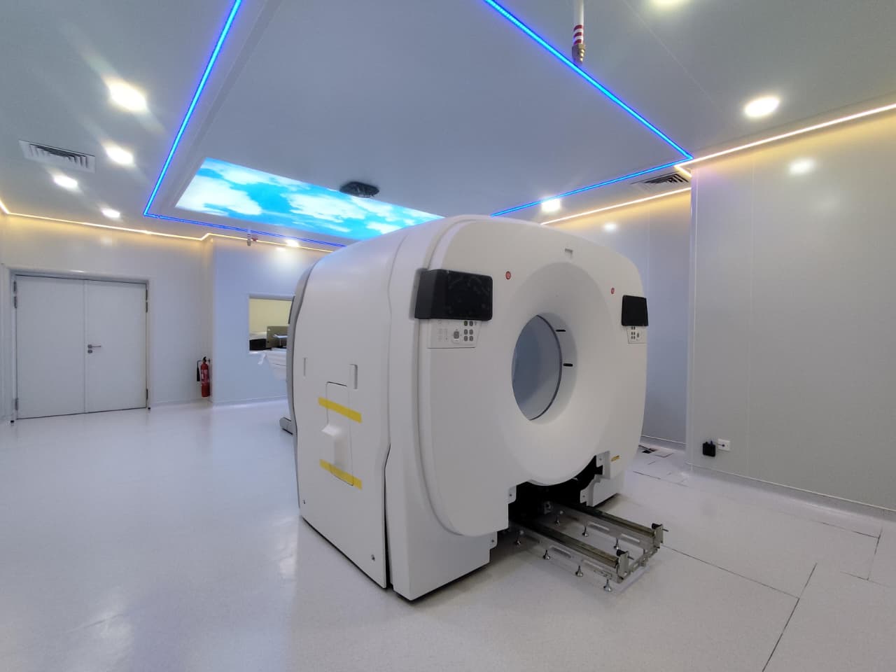 PET-CT scanner gantry in a completed panel-lined room with LED cove lighting